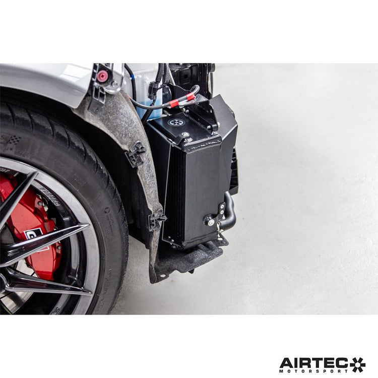 AIRTEC Motorsport auxiliary radiator for Toyota Yaris GR Gen2, showing the sleek black radiator with mounting brackets.