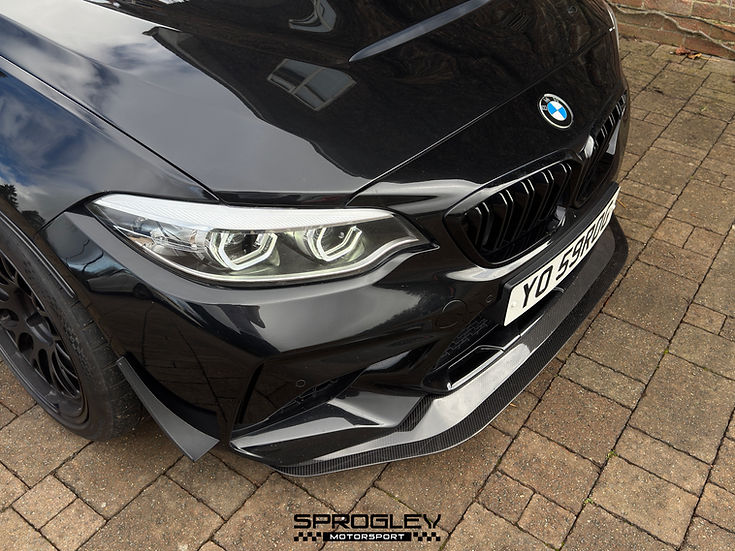 Sprogley Motorsport front bumper canards for F87 BMW M2, aerodynamic body styling accessories on a black car.