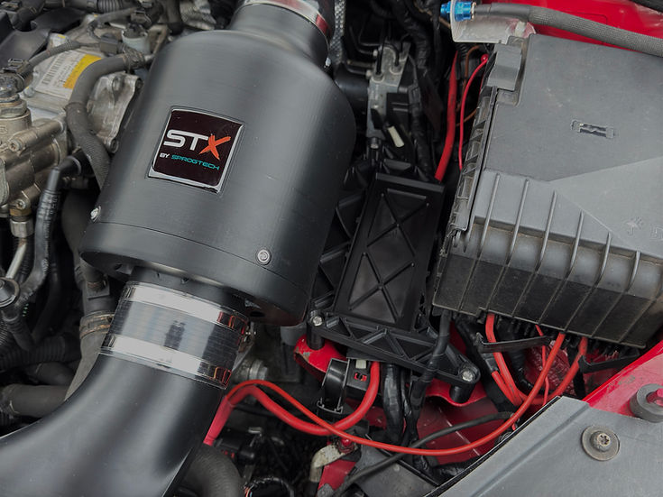 SprogTech STX EA3 enclosed intake kit for 2.0 TFSI engine, installed in a vehicle, showcasing sleek body styling and intake components.